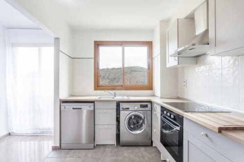 Cocina moderna en apartamento Rustikalpuente con electrodomésticos de acero inoxidable, marco de ventana de madera y vista a la montaña