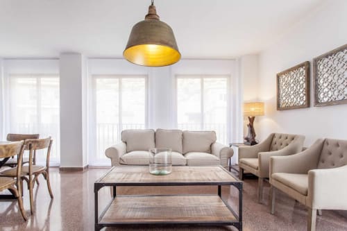 Sala de estar del apartamento Rustikalpuente con sofá beige, lámpara colgante, mesa de café de madera y ventanas luminosas