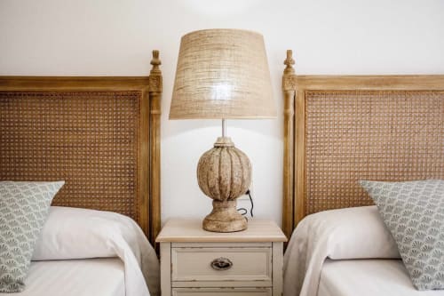 Camas gemelas con cabeceros tejidos y lámpara de noche en el apartamento Rustikalpuente en España