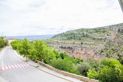 El apartamento Rustikalpuente domina un cañón escénico con acantilados de piedra caliza, valle verde y carretera sinuosa en España