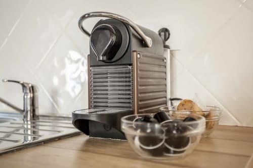 Cafetera Nespresso con cápsulas sobre encimera de madera en apartamento Rustikalpuente, España