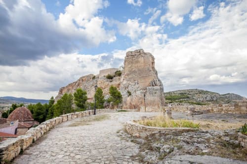 Ruinas de antigua fortaleza de piedra con torre en Rustikalpuente, España, rodeada de un hermoso paisaje montañoso