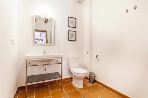 Baño moderno del apartamento Rustikalpuente con baldosas de terracota, lavabo tipo recipiente, inodoro y arte mural enmarcado
