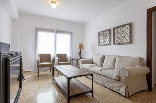Amplio salón del apartamento Rustikalpuente con sofá beige, sillones, chimenea y decoración moderna