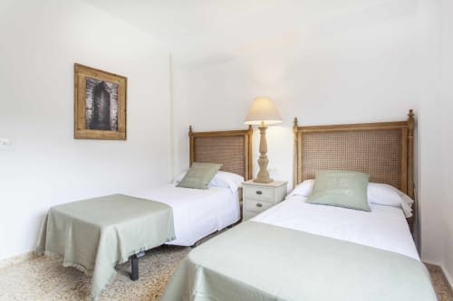 Dormitorio doble en apartamento Rustikalpuente con camas de madera, almohadas verdes y decoración tradicional