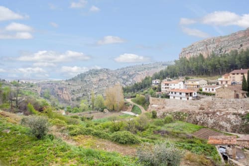 Apartamento Rustikalpuente con edificios rústicos en ladera con vistas a valle escénico, acantilados y vegetación