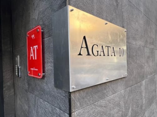 Señalización de entrada del edificio Agata 10 Apartamentos en Alicante con botón de emergencia rojo