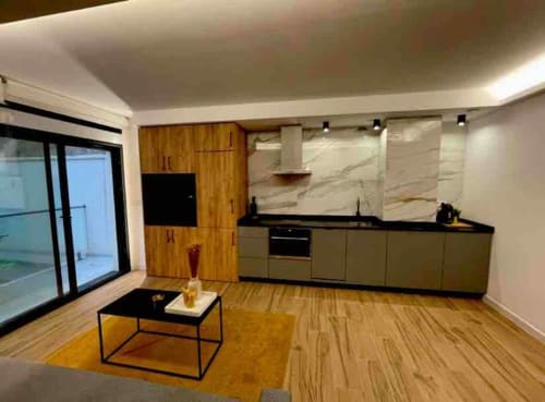 Cocina y sala de estar modernas en Agata 10 Apartamentos de Alicante con muebles de madera y vistas a la ciudad