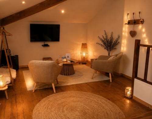 Coin salon confortable de la Suite Marquèze au Jardin d'Elusa BnB à Eauze, France, avec un éclairage chaleureux et du mobilier accueillant