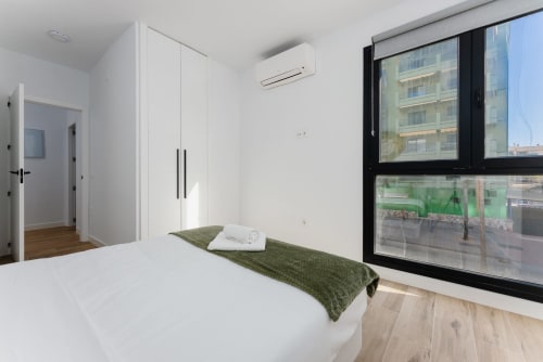 Dormitorio moderno en Ab Be Apartments, Fuengirola con vistas al mar, armario blanco y colcha verde