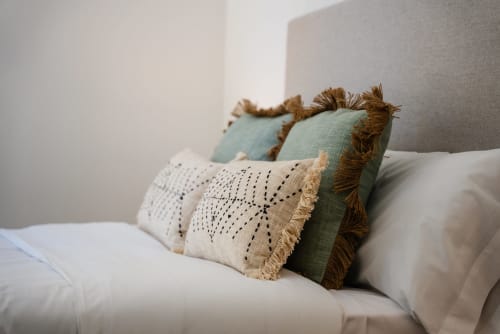 Cojines decorativos en la cama del Apartamento Ab Be en Fuengirola, Málaga - alojamiento cómodo con vistas al mar.