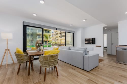 Moderno apartamento en Fuengirola con balcón con vistas al mar, salón, comedor con sillas amarillas y cocina en Málaga
