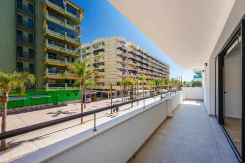 Soleada terraza balconada en Ab Be Apartments en Fuengirola, Málaga con vistas a la calle y edificios frente a playa