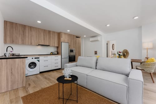 Apartamento moderno de planta abierta en Fuengirola con cocina, lavadora, sofá gris y suelos de madera en Ab Be Apartments