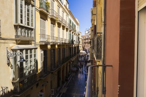 Encantadora vista de calle en Málaga desde Ab Be Apartments mostrando arquitectura española histórica y estrecho callejón peatonal