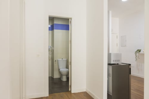 Entrada del baño en el apartamento AB BE Estudio, Málaga, con inodoro y piso de baldosas visible