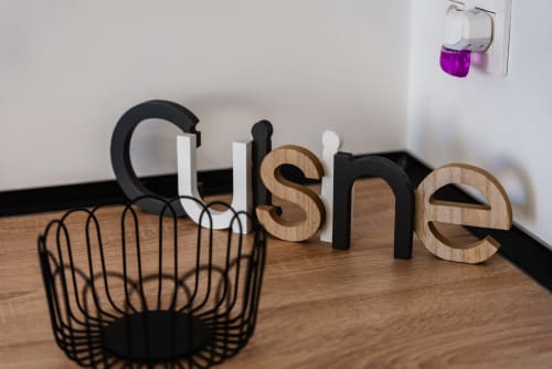 Decoración moderna del apartamento en Ab Be Apartments en Málaga con letras de madera y metal negras formando la palabra 'home'
