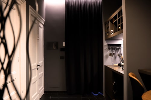 Ingresso della suite moderna presso Privitera Rooms con porte bianche, angolo cottura con ante in vetro e arredi scuri a Grammichele
