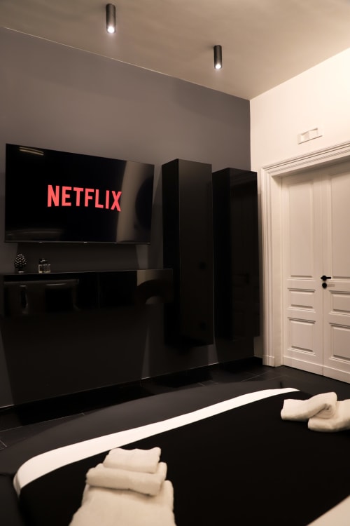 Suite Deluxe moderna con sala intrattenimento presso Privitera Rooms, TV a schermo piatto con Netflix, pareti nere e