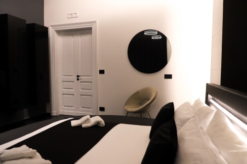 Camera Deluxe Modern Suite presso Privitera Rooms a Grammichele con parete nera in evidenza, letto bianco, specchio rotondo e