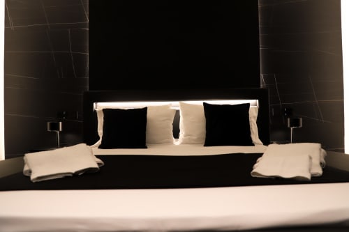 Camera Modern Suite Deluxe presso Privitera Rooms con parete in nero, testata illuminata, cuscini nero e panna