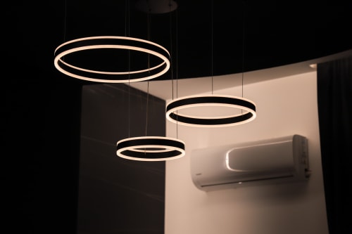 Lampade a sospensione moderne con anelli LED caldi nella Suite Deluxe di Privitera Rooms a Grammichele, con climatizzatore