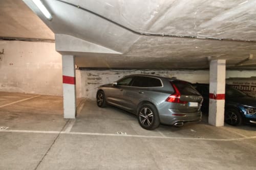 Underground parking garage at Finques Garcia Enrich with silver SUV in covered parking space, Palafrugell