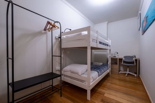 Quarto moderno com beliches no apartamento EcoHost Marina, piso de madeira, área de trabalho e cabideiro