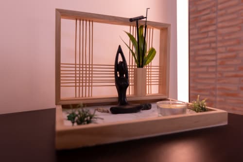 Canto de meditação Zen com estátua preta, plantas em vasos, vela e moldura de madeira no apartamento EcoHost