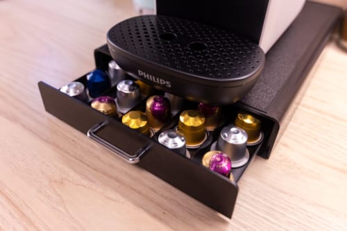 Máquina de café Philips com suporte colorido para cápsulas no apartamento EcoHost