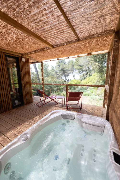 Hot tub on wooden deck with mountain views at Le chant des pins Lodges & Spas
