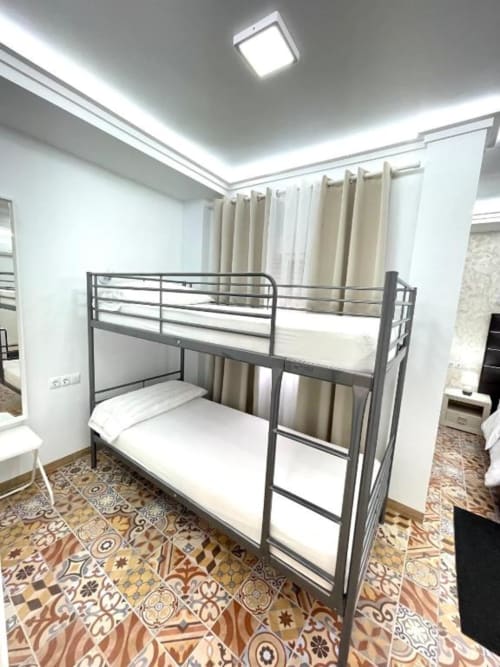 Litera metálica con colchones blancos en la luminosa Sala Familiar del Hotel Boutique Galeon en Calpe, España