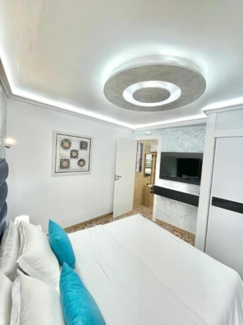 Habitación moderna del Hotel Boutique Galeon en Calpe con cama, TV e iluminación de techo contemporánea
