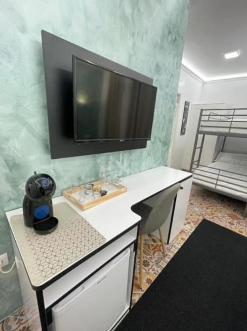 Habitación Familiar del Hotel Boutique Galeon en Calpe con TV de pared, escritorio y literas