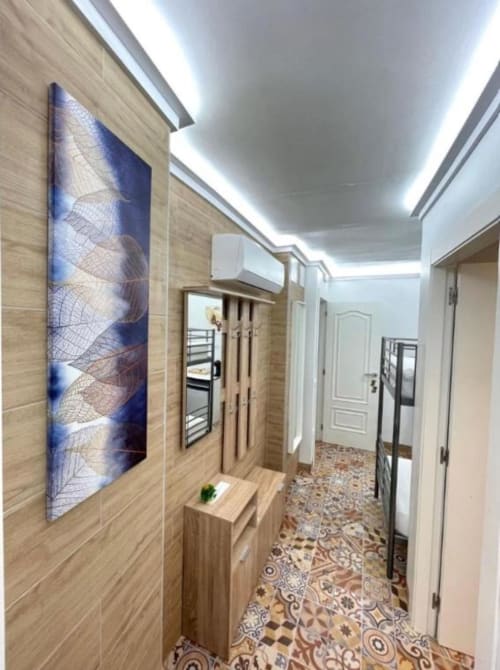 Moderno pasillo del Hotel Boutique Galeon Calpe con paneles de madera, arte azul, piso de diseño y iluminación LED