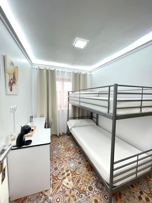 Habitación Familiar del Hotel Boutique Galeon en Calpe con camas literas, escritorio e iluminación moderna de techo blanco