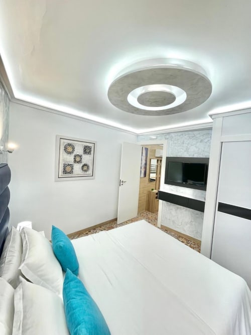 Moderna habitación doble en Hotel Boutique Galeon de Calpe con ropa de cama blanca, almohadas turquesas, luz LED de techo y