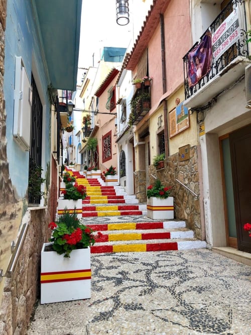 Coloridos escalones rojo y amarillo en encantador callejón del casco antiguo de Calpe, cerca del Hotel Boutique Galeon