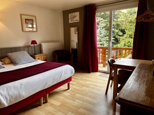 Habitación moderna en el Hôtel la Source en La Foux con cama queen, escritorio, balcón con vistas al jardín