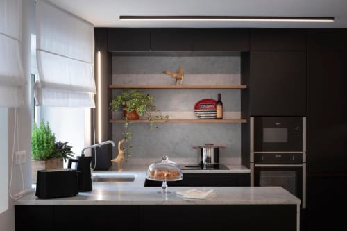 Cucina moderna nera presso Camere d'Aria B&B a Locana con piani in marmo, scaffali aperti e elettrodomestici contemporanei