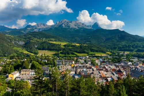 Hôtel la Source in La Foux with Alpine mountains, green valleys, and charming village nestled in French countryside