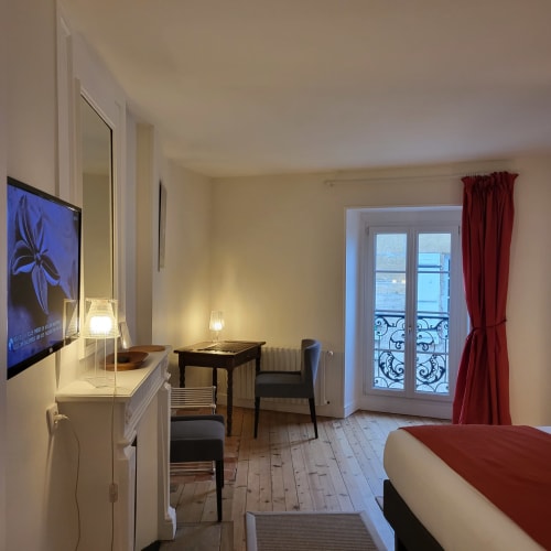 Chambre Salignac au Logis des Tourelles, Cognac : élégante chambre avec vue sur la ville, bureau, TV et portes-fenêtres à la française