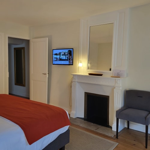 Chambre d'hôtel au Logis des Tourelles à Cognac avec cheminée, télévision et mobilier moderne