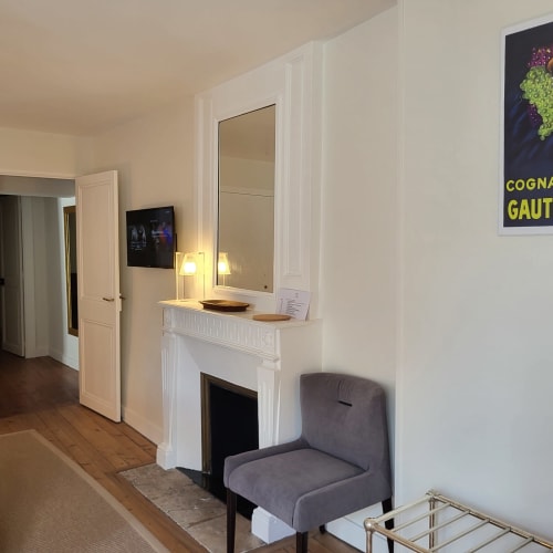 Entrée contemporaine de la chambre du Logis des Tourelles à Cognac avec cheminée, miroir et mobilier design