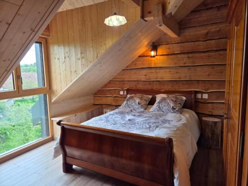 Chambre douillette sous les toits à La R'Mise de Surcey avec poutres apparentes, lit double et vue sur le jardin à Eternoz.