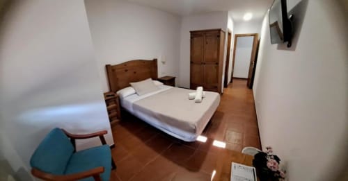 Habitación estándar en Hostal Monterde de Albarracín con cama doble, mobiliario de madera y baño privado