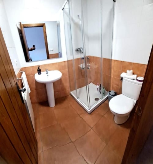 Baño privado con ducha, mampara de cristal y acabados funcionales en Hostal Monterde de Albarracín