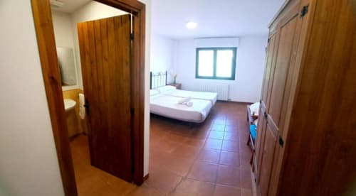 Habitación doble luminosa con baño privado y mobiliario de madera en Hostal Monterde de Albarracín