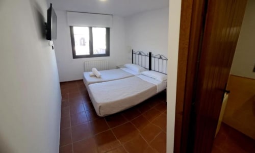 Habitación doble con dos camas individuales y luz natural en Hostal Monterde de Albarracín