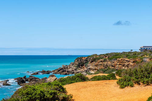 Vista desde acantilado de Barrosa Home con aguas turquesas del Mediterráneo, formaciones rocosas y acantilados dorados en España